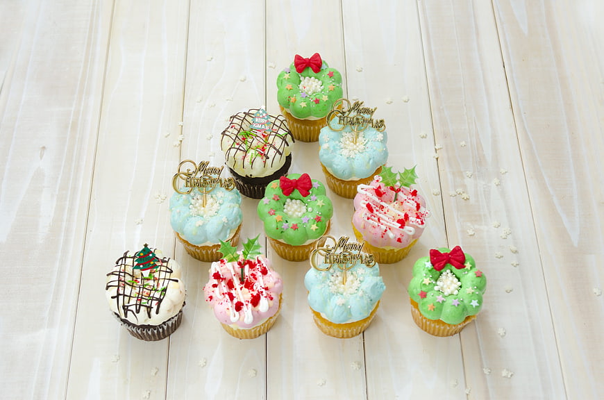 Christmas Cupcakes With Pastel Frosting And Red Bow Toppers