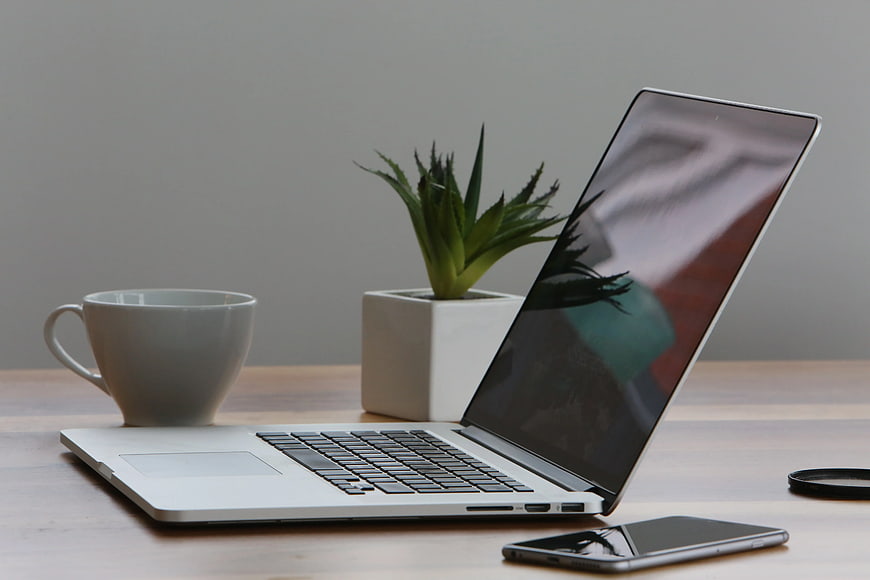 Modern Workspace with Laptop, Coffee, and Plant
