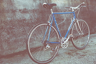 Vintage Blue Bicycle Leaning Against Textured Concrete Wall