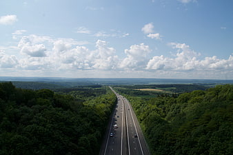 Aerial view of highway cutting through lush green forest