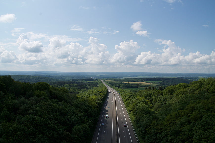Aerial view of highway cutting through lush green forest
