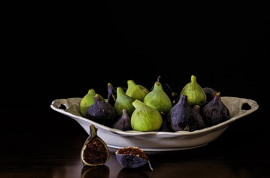 Fresh Green and Purple Figs in White Ceramic Bowl on Dark Background