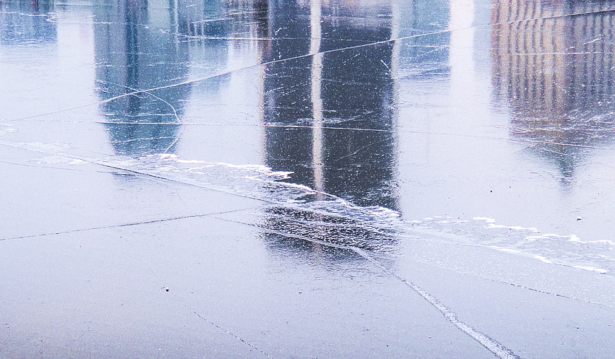 Cracked Ice Surface with City Building Reflections