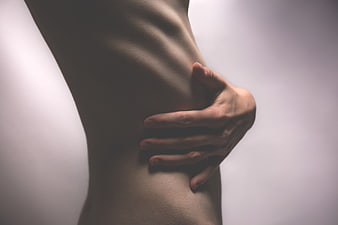 Close-up of woman's hand on ribcage torso