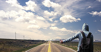 Hitchhiker on Country Road with Backpack and Mountains