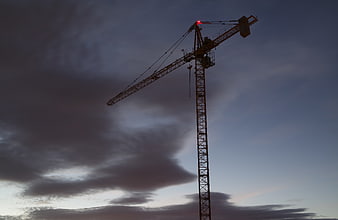 Silhouette of Construction Crane Against Dramatic Cloudy Sky