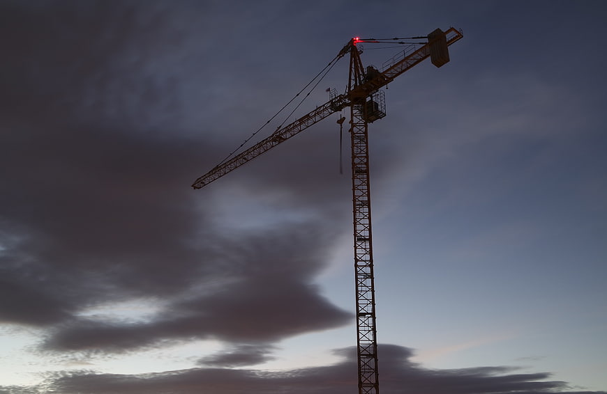 Silhouette of Construction Crane Against Dramatic Cloudy Sky