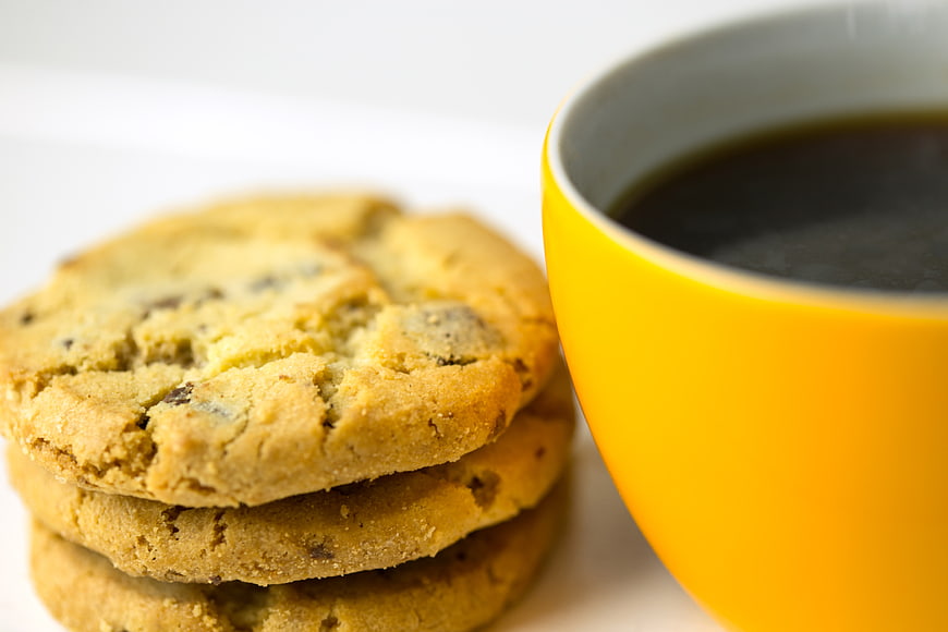 Stack of chocolate chip cookies with yellow coffee cup