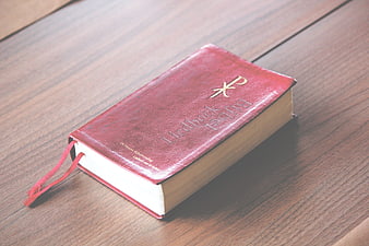 Red leather Bible on wooden table