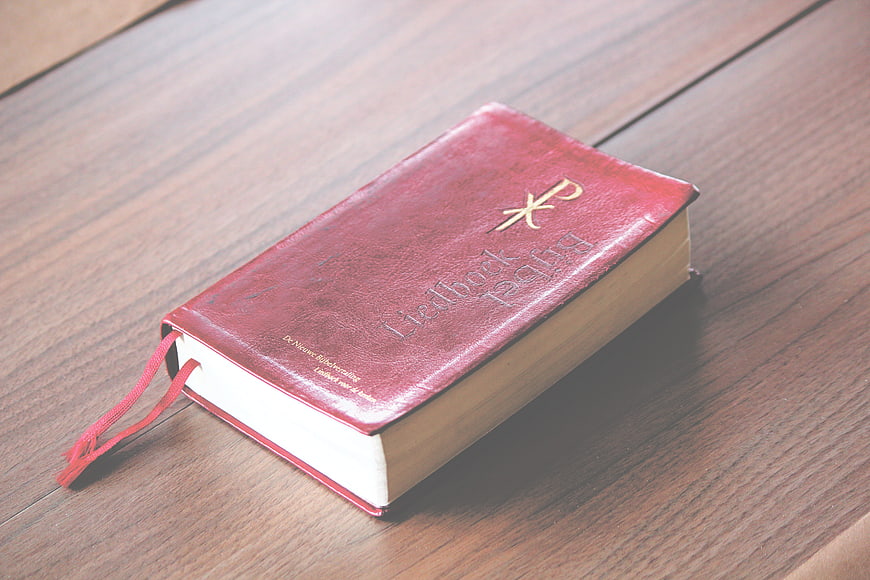 Red leather Bible on wooden table
