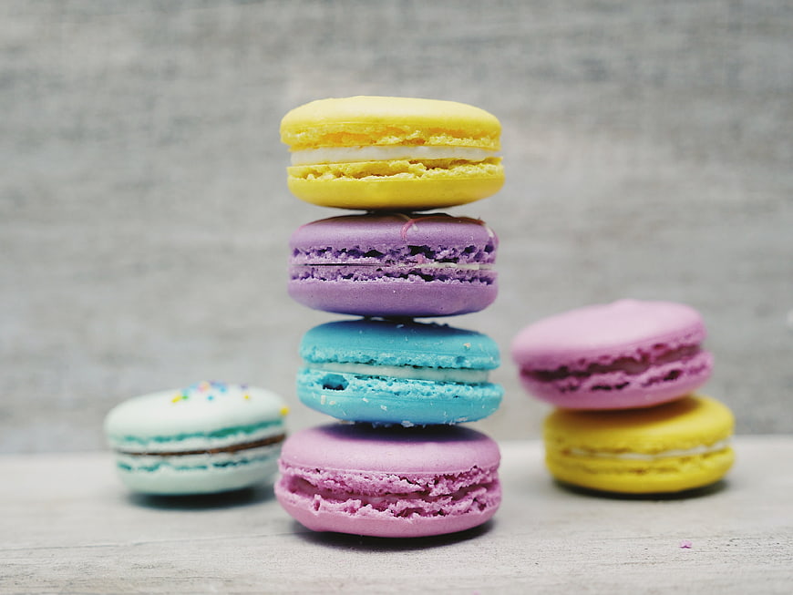 Colorful macarons stacked on a wooden table