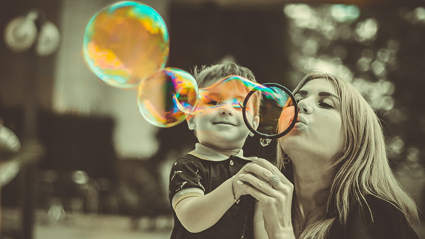 Mother and Son Blowing Colorful Soap Bubbles