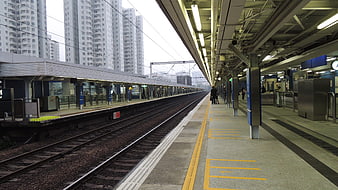 Empty elevated train station platform in Hong Kong with high-rise buildings