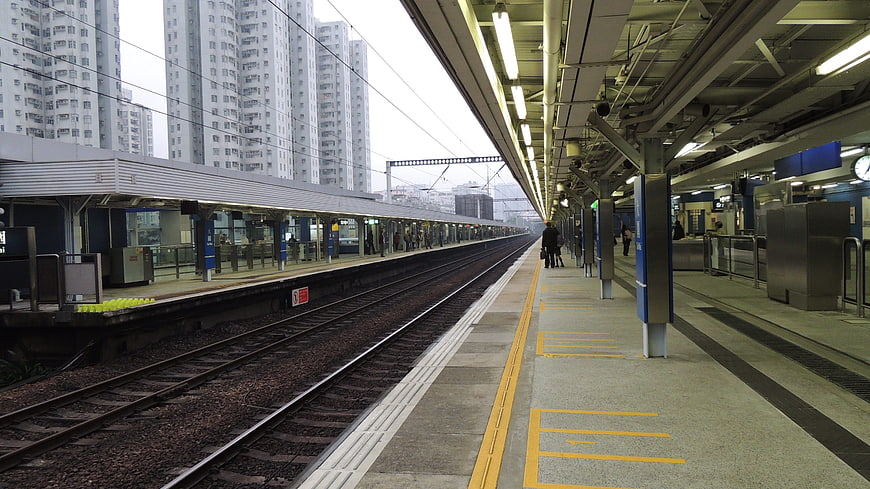 Empty elevated train station platform in Hong Kong with high-rise buildings
