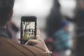 Man taking photo of city street with smartphone