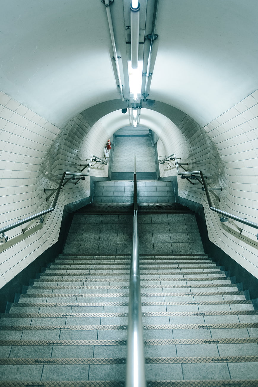 Symmetrical subway stairs leading up to bright exit