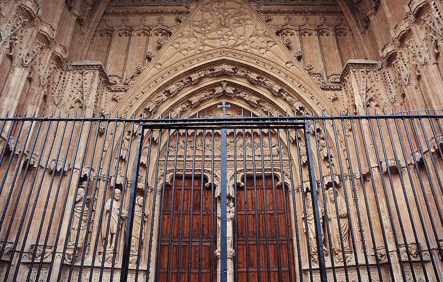 Gothic Cathedral Entrance with Iron Gate and Stone Carvings