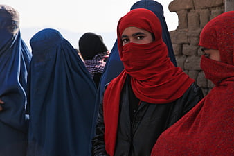 Afghan Woman In Red Burqa Standing With Blue Burqa Group
