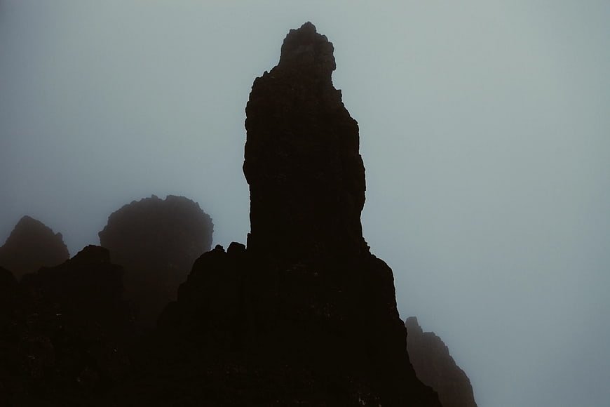 Silhouette of jagged mountain peak in thick fog