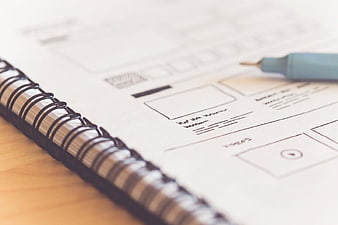 UX Wireframe Sketch in Spiral Notebook with Pen