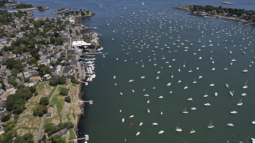 Aerial View of Harbor Filled with Sailboats and Coastal Town