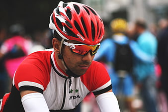 Focused male cyclist wearing red Uvex helmet and sunglasses