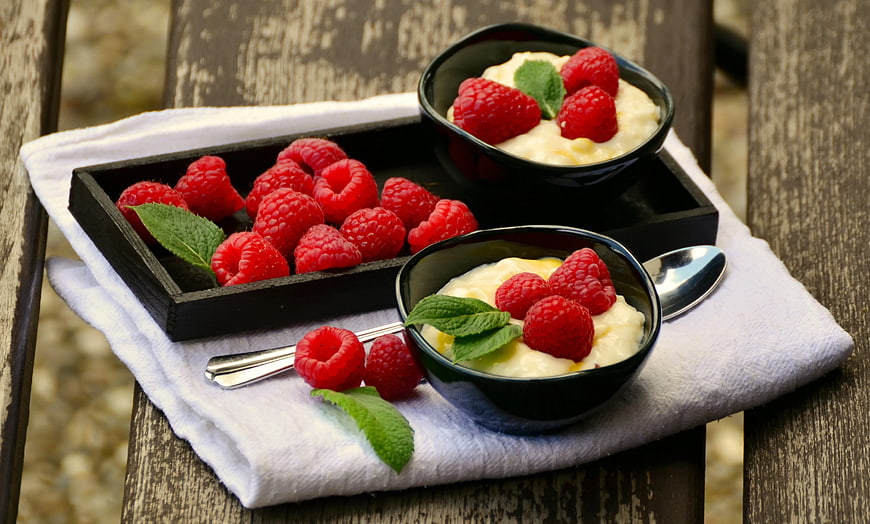Fresh Raspberries and Cream Dessert on Wooden Table
