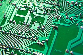 Close-up of green circuit board with solder points and text