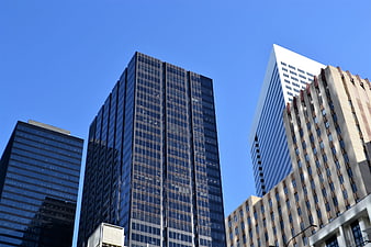 Low angle view of modern skyscrapers against blue sky