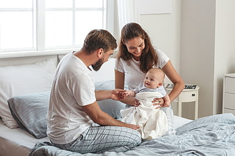 Happy Parents Playing with Baby in Bedroom