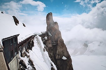 Snowy mountain peak with observation deck and clouds
