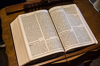 Open Bible on Wooden Stand with Warm Lighting