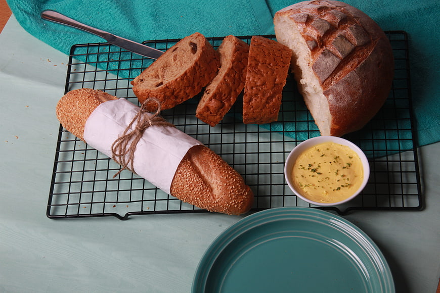 Artisan bread varieties on cooling rack with butter