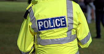 Back view of police officer in high-visibility yellow jacket