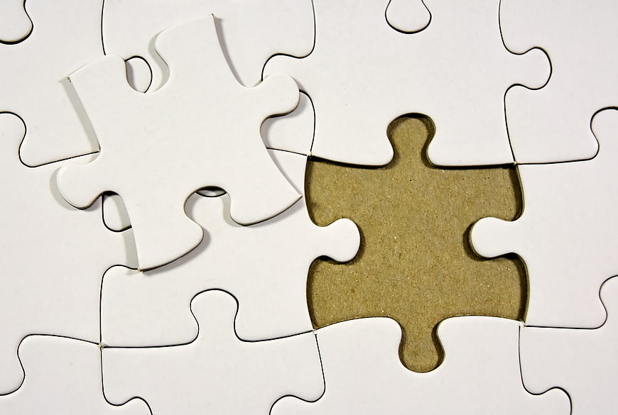 White puzzle pieces with missing piece and loose piece