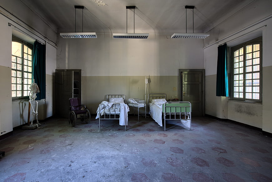 Abandoned Hospital Ward Interior With Old Beds And Skeleton