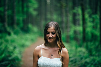 Serene Woman in White Lace Top Walking on Forest Path