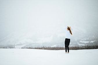 Woman in winter gear standing in snowy landscape