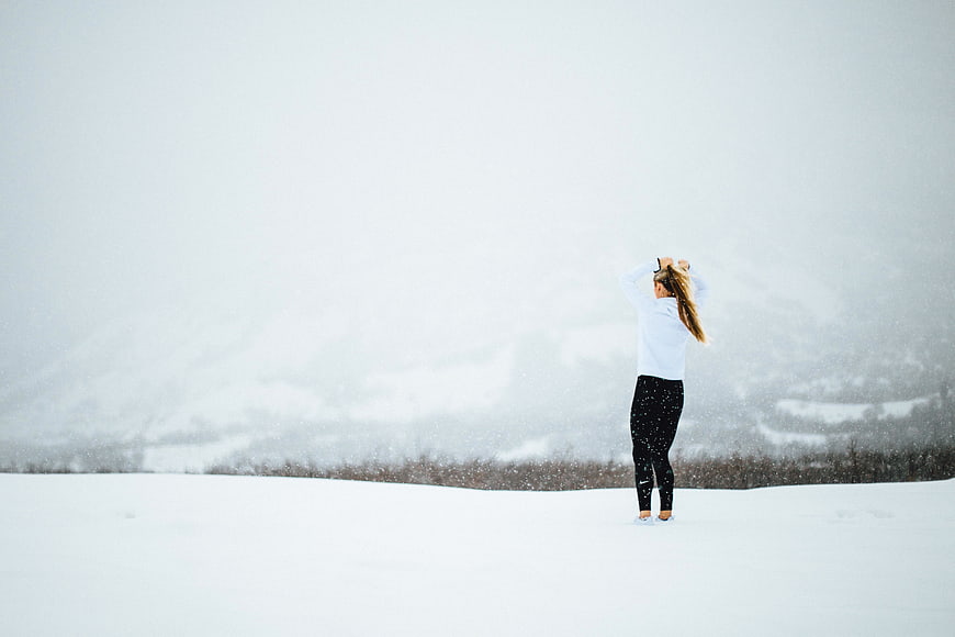 Woman in winter gear standing in snowy landscape
