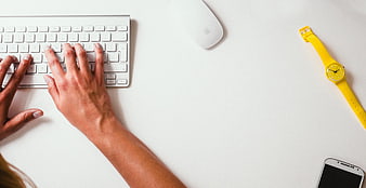 Top View of Hands Typing on White Keyboard with Yellow Watch