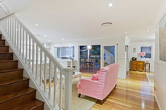 Bright Modern Home Interior With Wooden Staircase And Pink Armchair