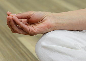 Close-up of hands in meditation mudra on knee