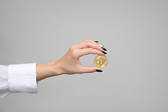 Woman's Hand Holding Physical Bitcoin Coin on Gray Background