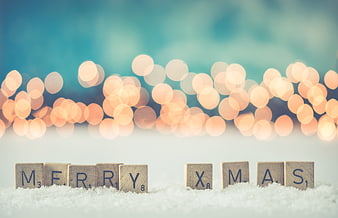 Merry Christmas Scrabble Tiles on Snow with Bokeh Lights