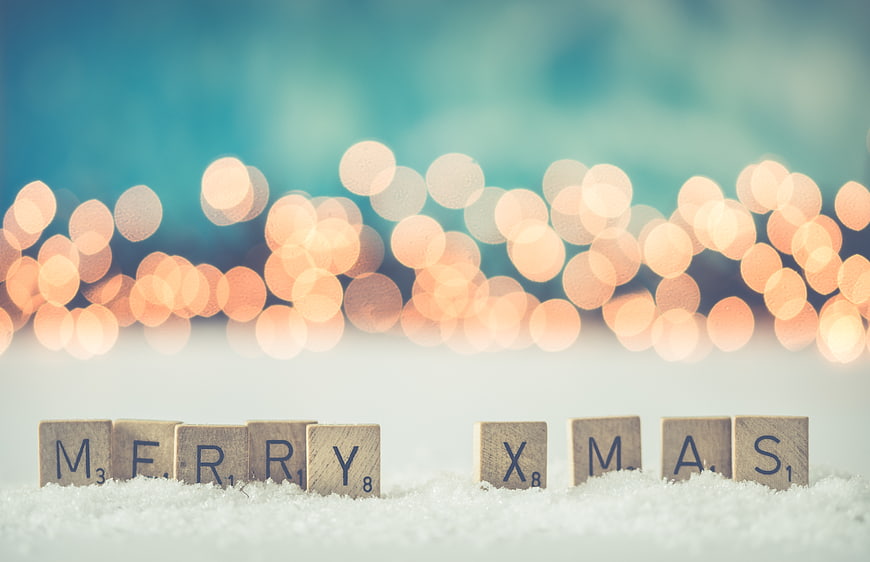 Merry Christmas Scrabble Tiles on Snow with Bokeh Lights