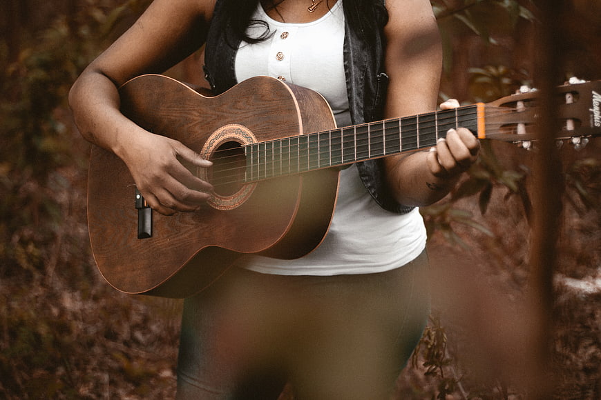 Woman Playing Acoustic Guitar in Forest