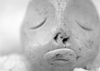 Close-up of a clay sculpture face with closed eyes