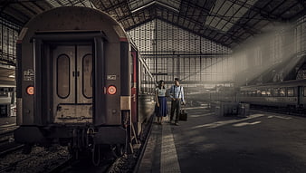 Couple with luggage standing on train station platform