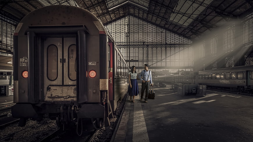 Couple with luggage standing on train station platform