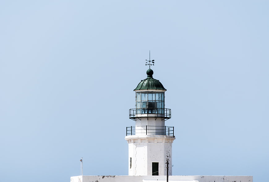 White Lighthouse Tower Top Against Clear Blue Sky